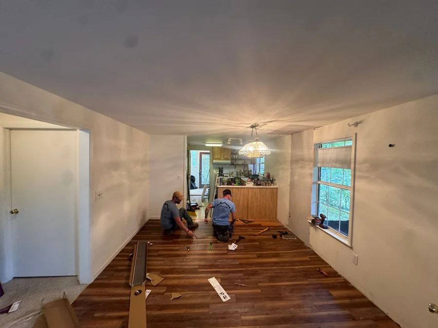 Crew laying hardwood flooring during an interior remodel