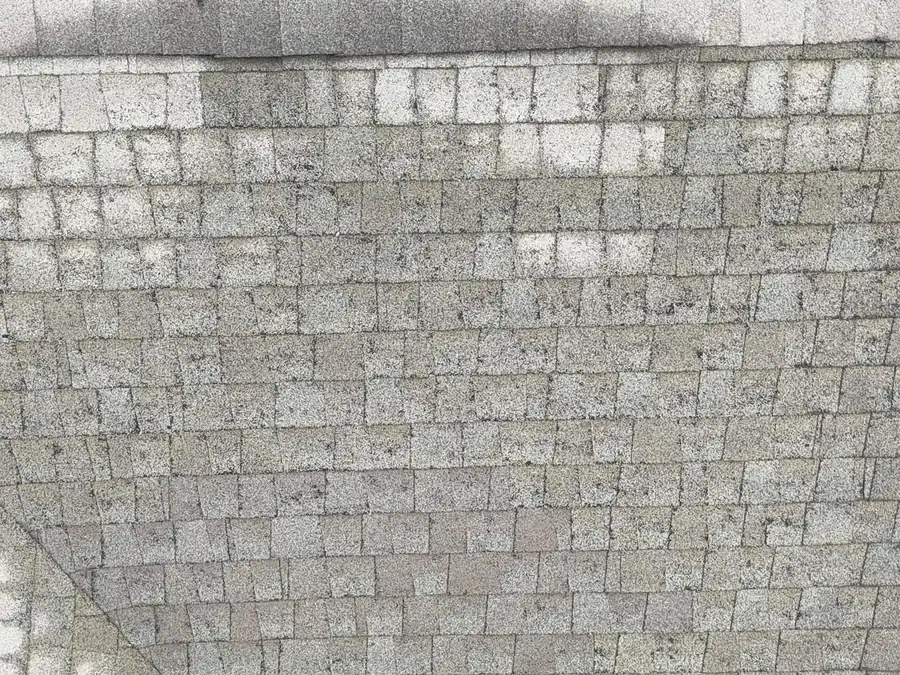Hail bruising across asphalt shingles, documented from above for an insurance adjuster